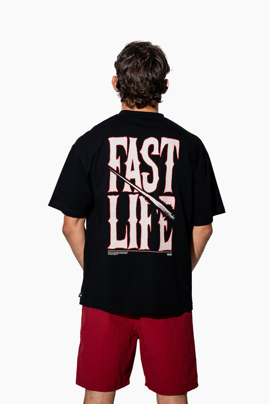 Man wearing a black t-shirt with FAST LIFE on it and red shorts on a white background