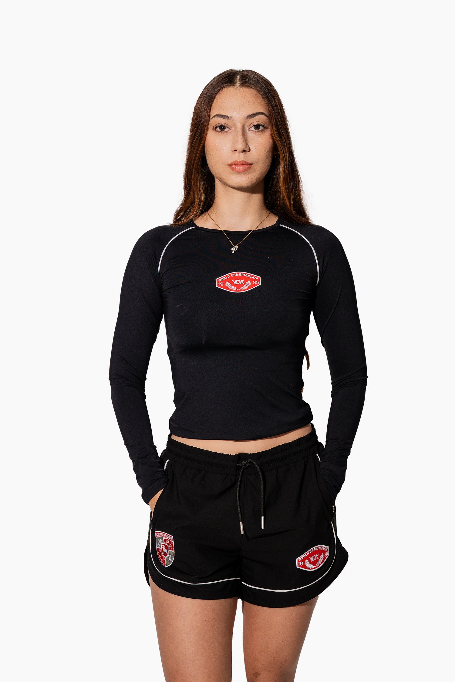 Woman wearing a black athletic outfit with red logos on a white background